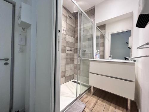 a bathroom with a glass shower and a sink at Tour d'Auvergne - Appartements en plein centre ville, proche de la cathédrale et de la place de Jaude in Clermont-Ferrand