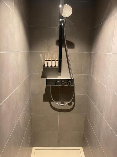 La salle de bains est pourvue d'une douche avec une lumière sur le mur. dans l'établissement Appartement standing face mont blanc piscine, à Megève