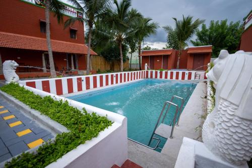 a swimming pool with a white fence around it at CHETTINAD HERITAGE WELLNESS RESORTS in Mithilaipatti