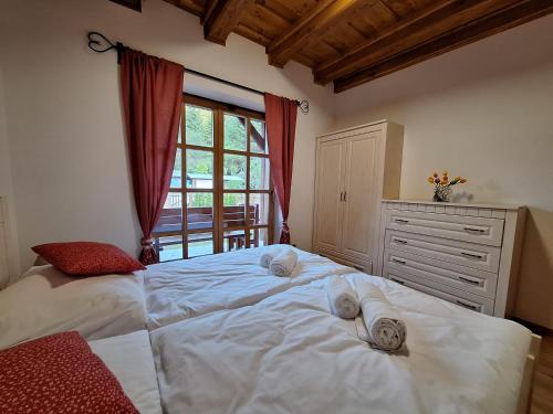 a bedroom with a large white bed and a window at Apartmán Jezerné in Velké Karlovice