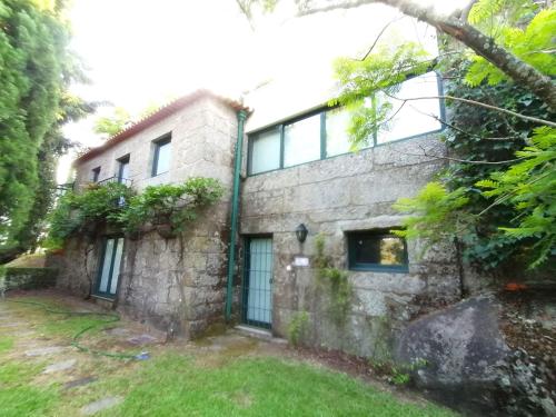 Cette ancienne maison en pierre possède des fenêtres et une cour. dans l'établissement Casa das Feitorias Douro Valley, à Baião