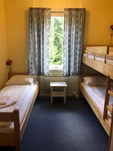 a room with two bunk beds and a window at Tronsvangen Seter in Alvdal
