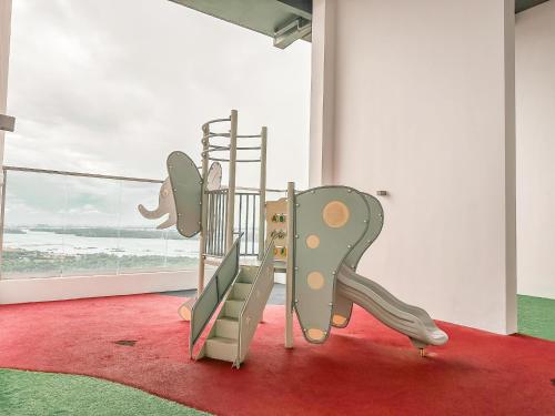 un parque infantil con tobogán en una habitación con ventana en [Starry x CREAM] Sea View Apartment 10-12pax *FREE Netflix, en Masai