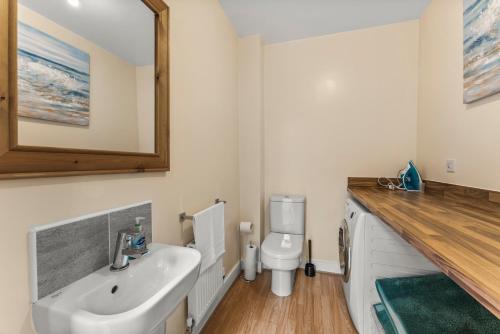 a bathroom with a sink and a toilet at Sleek and Stylish 2 Bed with Garden and Parking in Sheffield