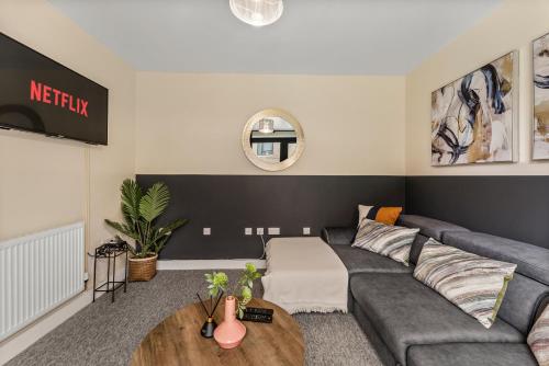 a living room with a gray couch and a wooden table at Sleek and Stylish 2 Bed with Garden and Parking in Sheffield