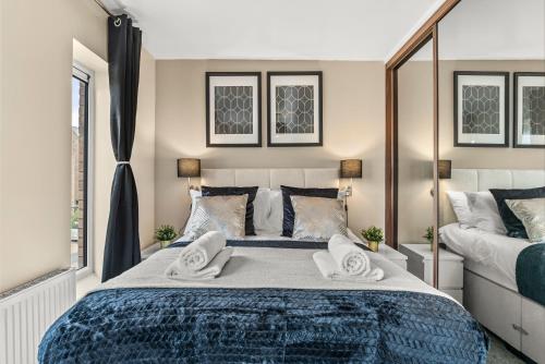 a bedroom with a large bed with towels on it at Sleek and Stylish 2 Bed with Garden and Parking in Sheffield