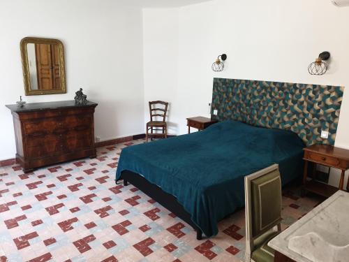 une chambre avec un lit, une commode et un miroir dans l'établissement Gîte de la fontaine, à Buisson