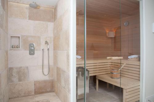 une douche avec une porte vitrée dans une salle de bain dans l'établissement Strandhaus-Mylin, à Westerland