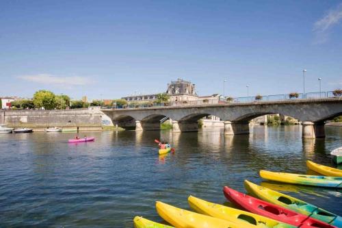 a group of kayaks in the water next to a bridge at Maison cosy avec parking gratuit in Jarnac