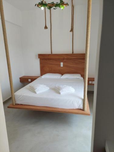 a bedroom with a swing bed with white sheets at Golden Star Praxitelous in Agia Marina Aegina