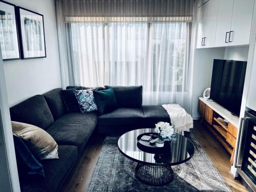 a living room with a couch and a glass table at Ruckers Hill Northcote Penthouse in Melbourne