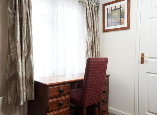 a desk with a chair next to a window at Bull Hotel by Greene King Inns in Halstead