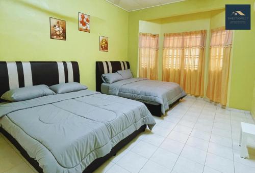 due letti in una stanza con pareti verdi di Sweet Home_30( 15 mins to Jonker Street ) a Malacca