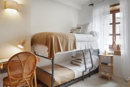 a bedroom with two bunk beds and a chair at Nin de Beret 2 by FeelFree Rentals in Naut Aran