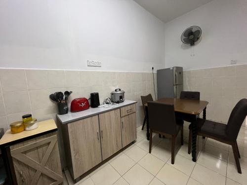 a kitchen with a table and a table and a refrigerator at RUMAH MURNI by IMPIAN HOMESTAY KLIA-SALAK TINGGI-NILAI in Sepang