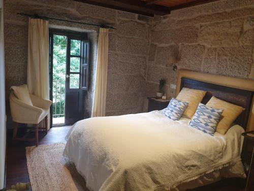 a bedroom with a bed with blue and white pillows at Casa Rural O Bergando in Cotobade