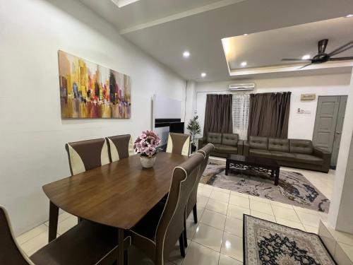 - une salle à manger avec une table, des chaises et un canapé dans l'établissement RUMAH MURNI by IMPIAN HOMESTAY KLIA-SALAK TINGGI-NILAI, à Sepang