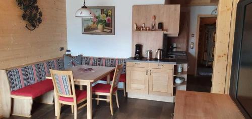a kitchen with a wooden table and chairs and a table and a counter at Haus Walina in Tannheim