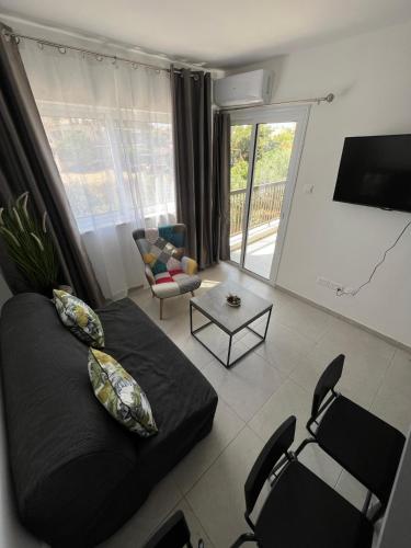 a living room with a black couch and chairs at Stay With Oleg C111 in Paralimni