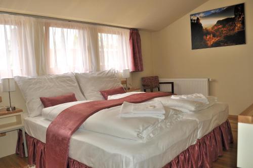 a large white bed in a room with windows at Penzion Lípa in Krásná Lípa