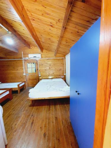 a room with a bed and a wooden ceiling at TONEDA Seaside Bungalows in Dhërmi