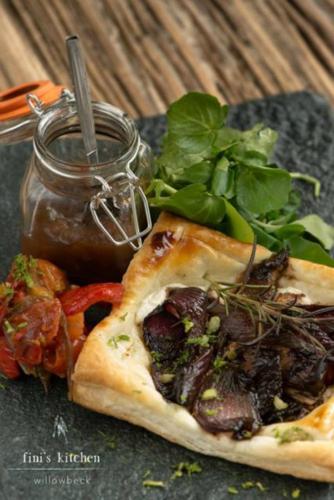 a slice of pizza with greens and a jar of sauce at Willowbeck Lodge Boutique Hotel in Carlisle