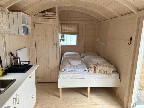 a bed in the middle of a tiny house at Tiny Beach House in Barkelsby