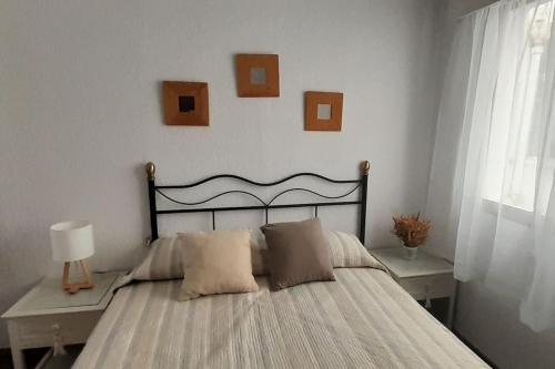 1 dormitorio con 1 cama con cuadros en la pared en Apartamento Huelva Centro, en Huelva