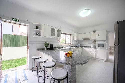 a kitchen with a table and some stools in it at CASA AMARELA in Charneca