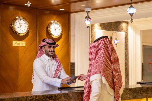 a man standing next to a woman in a counter at Swissotel Al Maqam Makkah in Makkah