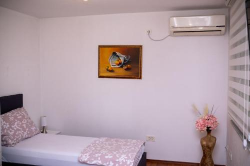a bedroom with a bed and a picture on the wall at Apartment Mery in Mostar