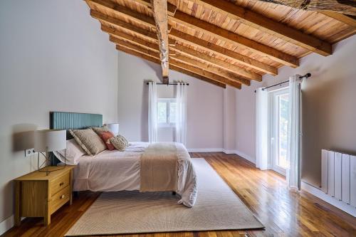 a bedroom with a bed and a wooden ceiling at Ojangoiti with outlet for electric vehicle By Kabia Gestión in Gautegiz Arteaga