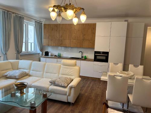 a living room with a white couch and a table at Apartamenty pod Katedrą in Bielsko-Biała