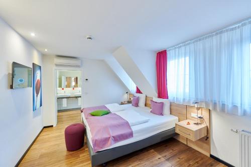 ein Schlafzimmer mit einem Bett mit lila Kissen in der Unterkunft Das Crass in Nieder-Olm