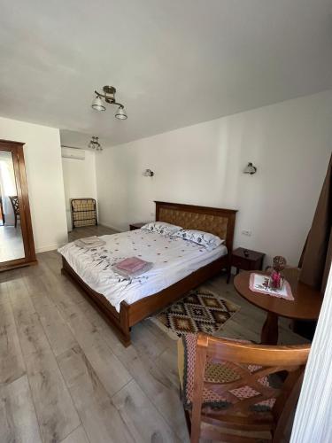 a bedroom with a large bed and a table at La Mona in Bîrsana