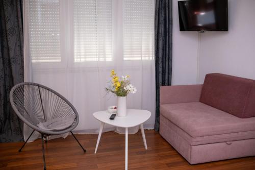 a living room with a couch and a table and a chair at Apartment Mery in Mostar