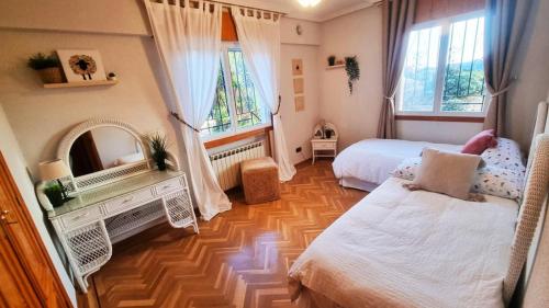 een slaapkamer met 2 bedden en een houten vloer bij Donde Portela in Almorox