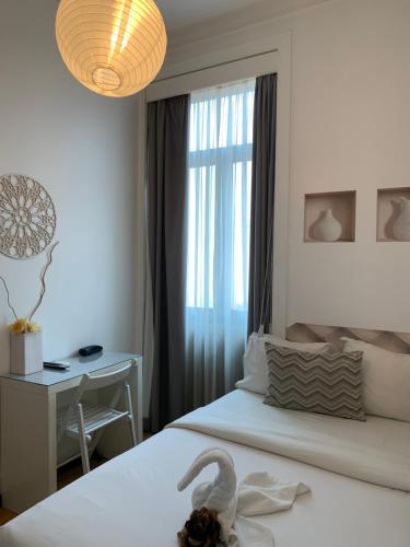 Un dormitorio con una cama y un escritorio con un cisne. en Pensao Central, en Matosinhos