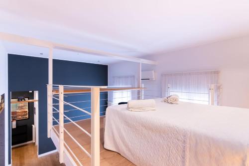 a bedroom with a white bed and a blue wall at Oliveri Vintage House at Politeama in Palermo