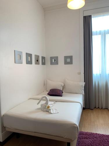 um quarto com duas camas com um cisne em Pensao Central em Matosinhos
