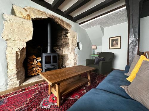 a living room with a wooden table and a fireplace at Cosy Cottage in Lechlade in Lechlade