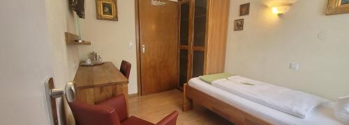 a small room with a bed and a table and chairs at Gästehaus Casa Cristina in Bad Krozingen