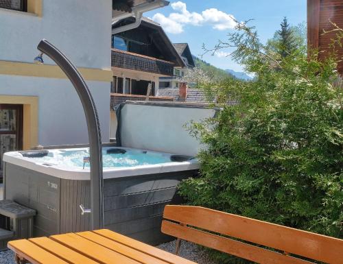 a hot tub on the side of a building with a bench at Jacobs 4 Bedroom Private House in Kranjska Gora