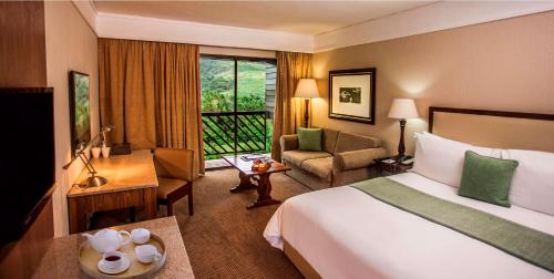 Pokój hotelowy z łóżkiem i biurkiem w obiekcie Drakensberg Sun Resort w mieście Winterton