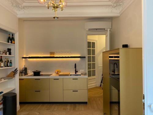a kitchen with white cabinets and a stove top oven at Paris 8 golden triangle - fancy brand new appt in historic building in Paris