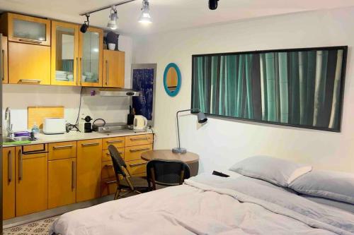 a bedroom with a bed and a table and a kitchen at Studio in the best place of town! in Tel Aviv