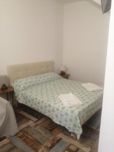 Appartamento Severino - Rariche House في كاميروتا: غرفة نوم صغيرة مع سرير مع لحاف أخضر