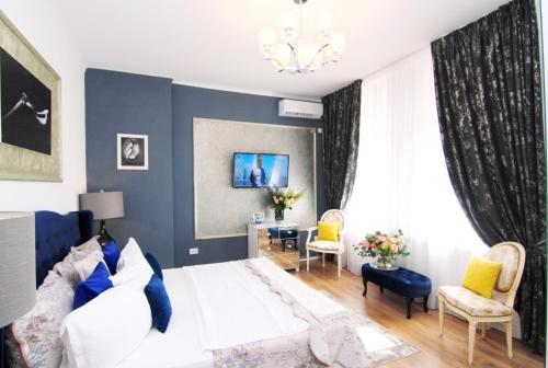 KAS 1Bd apartment unique central Unirii Bucharest في بوخارست: غرفة معيشة مع أريكة بيضاء وجدار أزرق