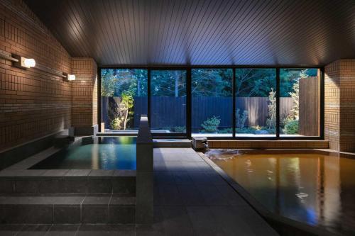 a swimming pool in a house with a large window at Hotel Omaruyama in Sakura