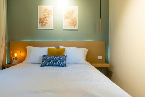 a bedroom with a white bed with two pillows at BIRD NEST Near Arkan Plaza in Cairo